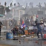 Some Followers Of Baba Rampal Throw Bricks and Others Cover Themselves Of The Water Canon