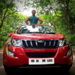 Devdatta Nage poses with his Mahindra XUV500 car
