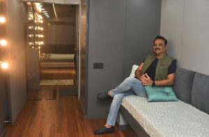Naresh Babu posing in his luxurious Caravan